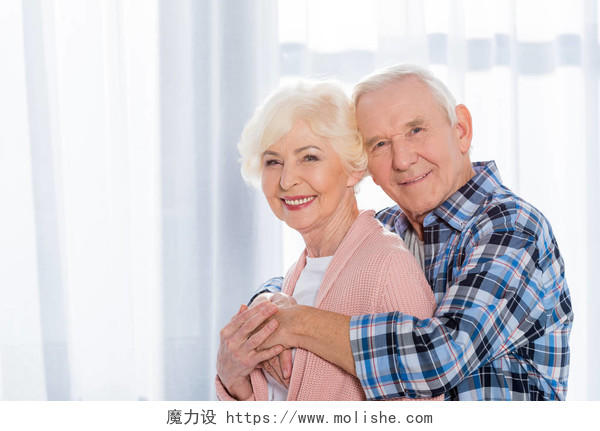 幸福看着相机的老年夫妇的肖像照片